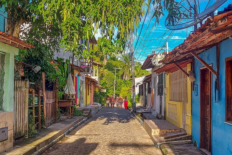 Colourful houses on a sandy street in the village of Boipeba