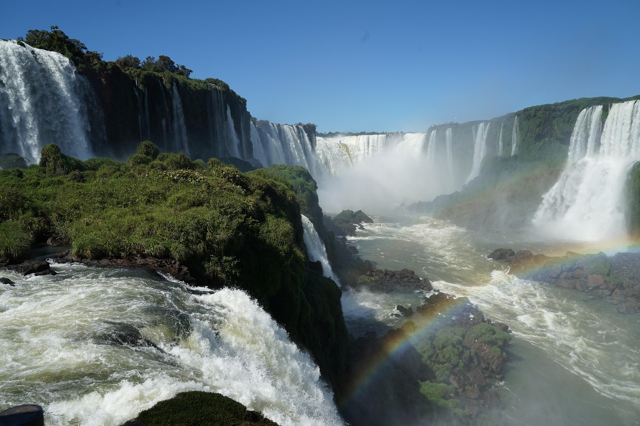 Iguaçu Falls cascading through the Atlantic Forest with a rainbow over the river